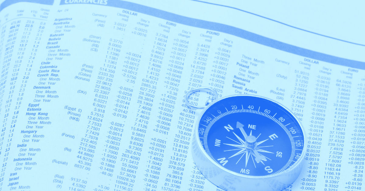 Compass placed on top of a newspaper report of daily stock market data