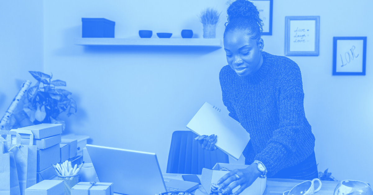 Business owner reviews accounting records in front of packaged products on her desk